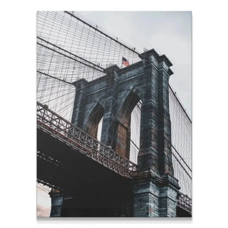 Low-angle view emphasizing the massive stone tower of the Brooklyn Bridge.