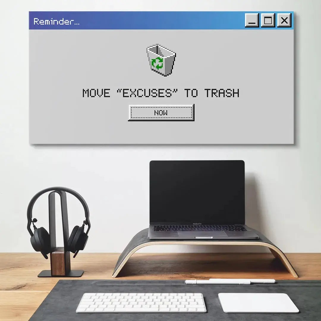 Lifestyle photo of the 'Delete Excuses' poster hanging in a modern home office setup.