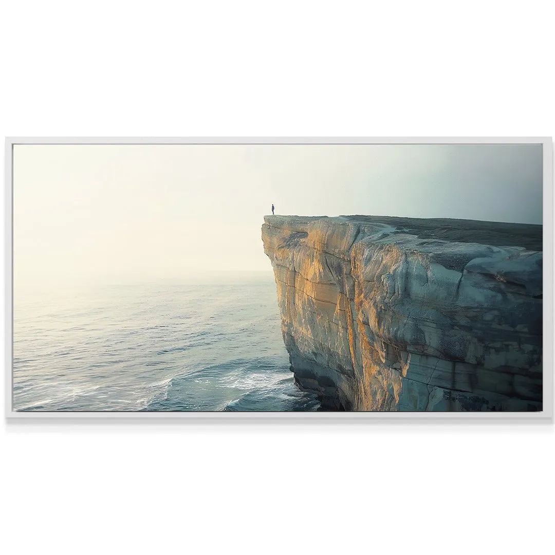 A solitary figure standing on the very edge of the vast Dramatic Cliff overlooking the misty ocean.