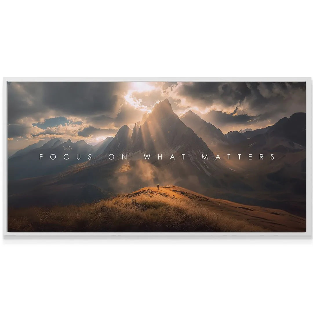Dramatic sunburst rays illuminating sharp peaks behind the text "Focus On What Matters"