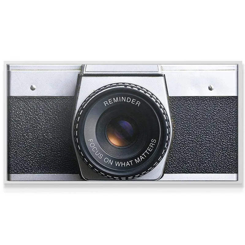 Textured detail of the black leatherette grip on the 'Focus On What Matters (Camera)' body, emphasizing materials.