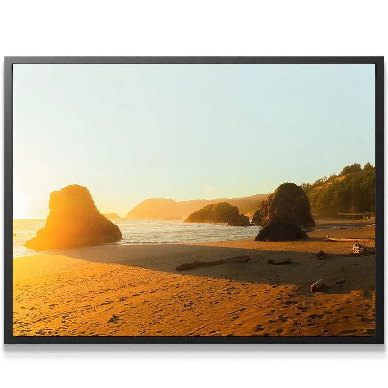 Wide-angle view of the beach shoreline and multiple dark sea stacks under the vibrant 'Golden Glow' atmosphere.