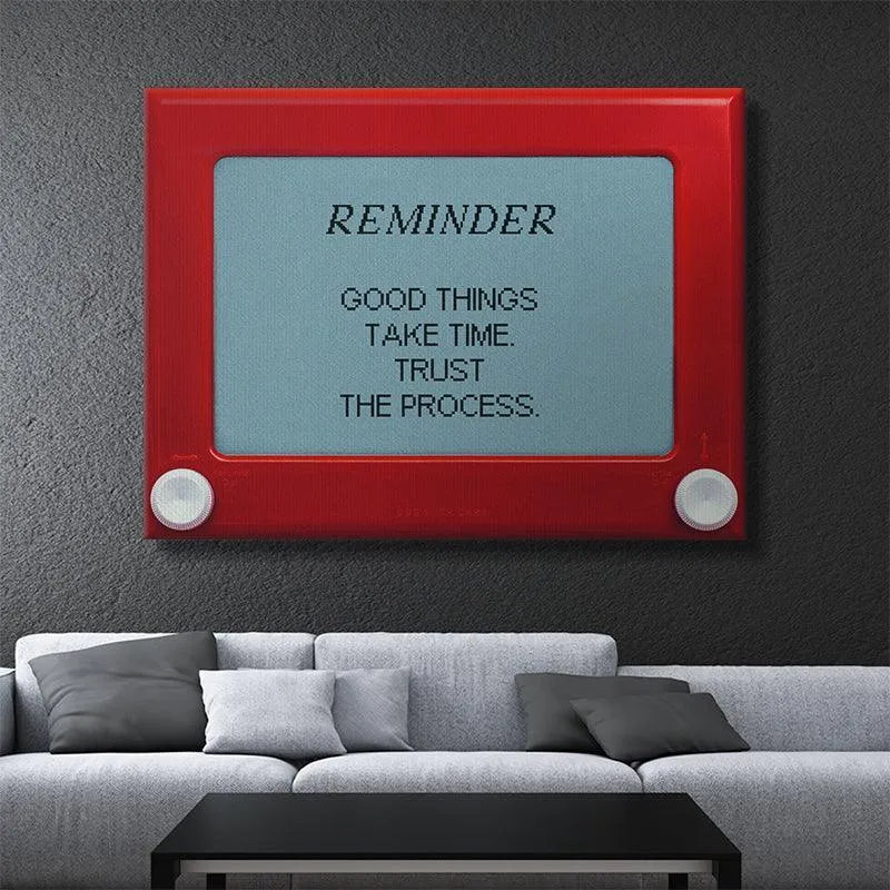 Macro detail of the white turning knobs on the Etch A Sketch style piece featuring 'Good Things Take Time'.