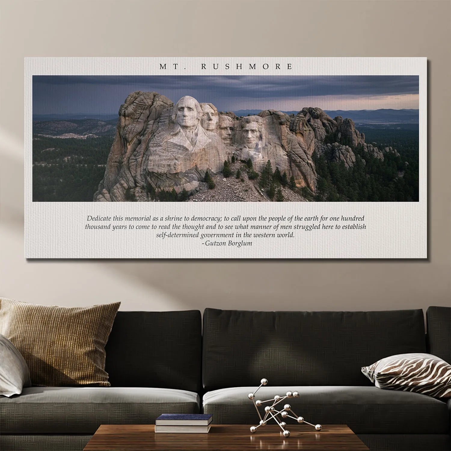 Wide view of the canvas art Gutzon Borglum - Mt. Rushmore displayed above a modern dark sofa.