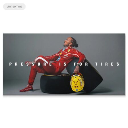 Full horizontal shot of Lewis Hamilton seated calmly on the tire with the statement "Hamilton - Pressure Is for Tires".