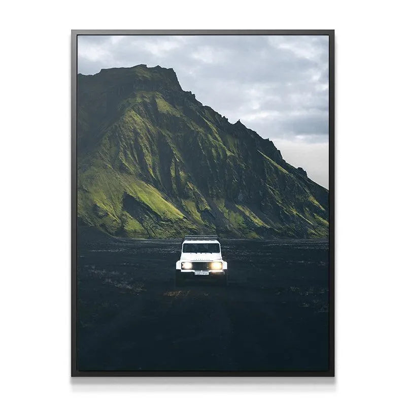 Close-up view of the vehicle's illuminated headlights against the dark volcanic soil of the Highlands.