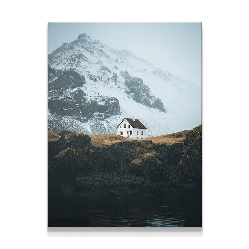 Remote white Home nestled on a rugged cliffside overlooking dark water.
