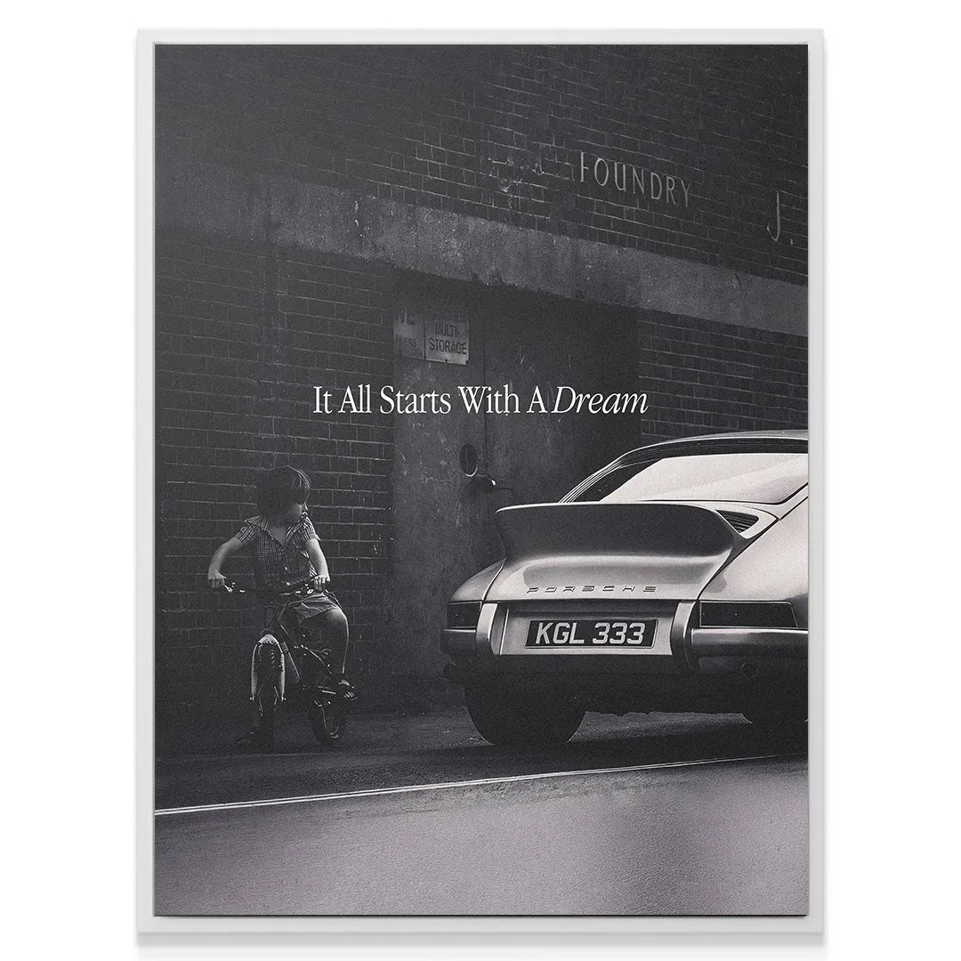 Rear angle detail of the classic Porsche 911 rear spoiler and bumper, set against the backdrop of the motivational quote 'It All Starts With A Dream'.