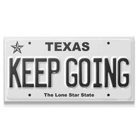 Standard, straight-on view of the embossed metal sign reading 'Keep Going - TX'.