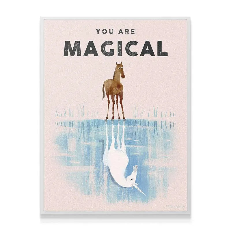 Lifestyle image of the 'Kids You Are Magical' framed print hanging above a child's bed in a pastel room.
