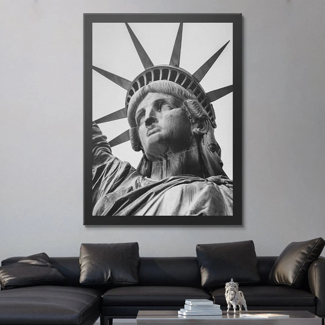 Monochrome framed art capturing the head and spiked crown of Lady Liberty against a bright sky.