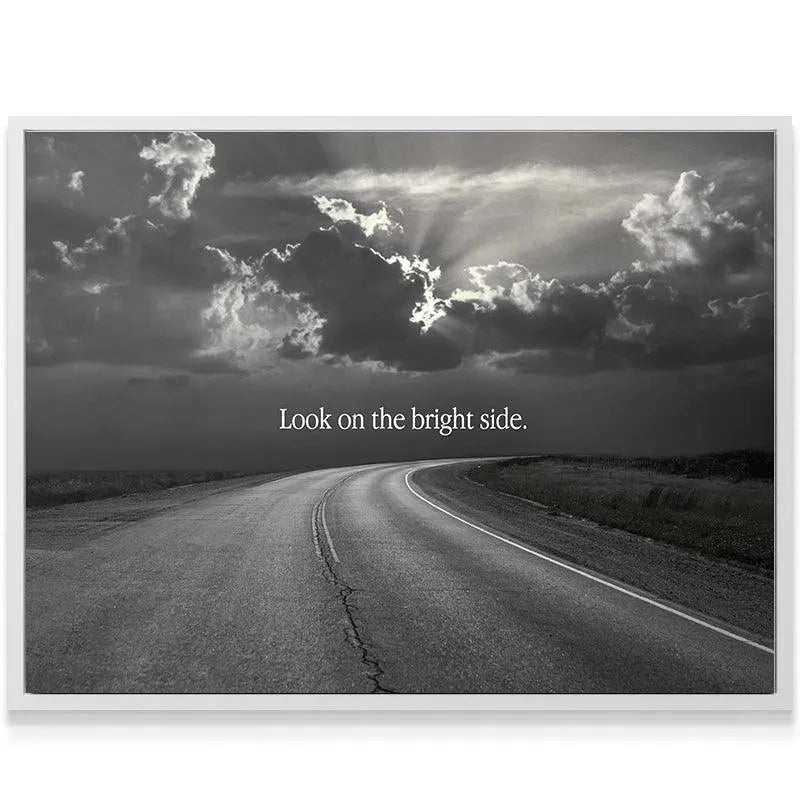 Dramatic monochrome artwork showing sun rays breaking through storm clouds above the text Look On The Bright Side.