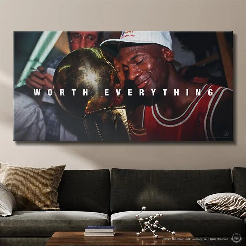 Large canvas print of a basketball player holding a trophy with 'Worth Everything' text above, hanging on a wall above a couch.
