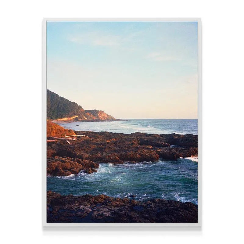 Wide-angle view showcasing the rolling forested hills above the 'Seaside' shoreline at sunset.