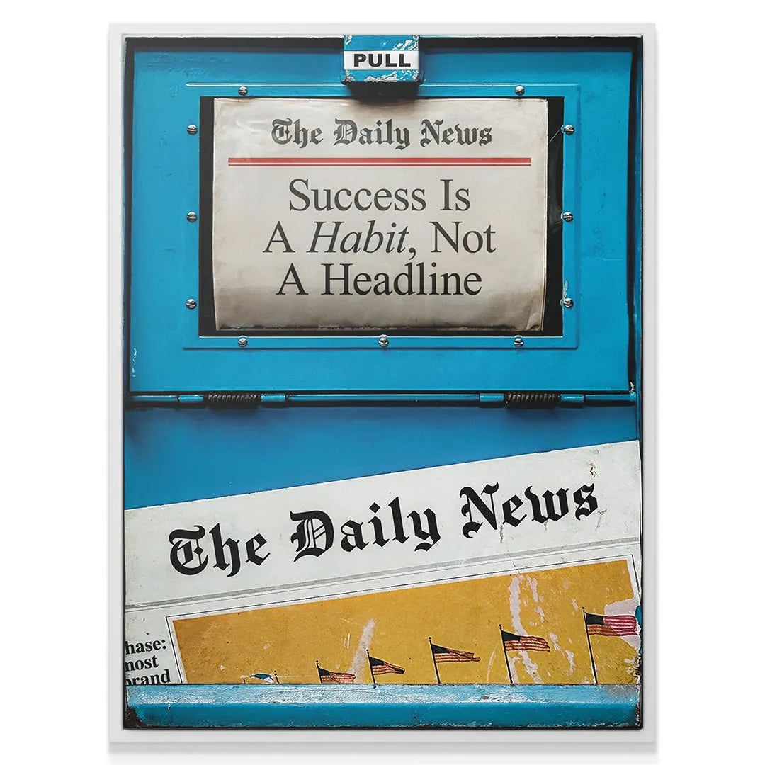 High-angle view showing the "PULL" handle detail on the blue dispenser above the 'Success Is A Habit' newspaper display.