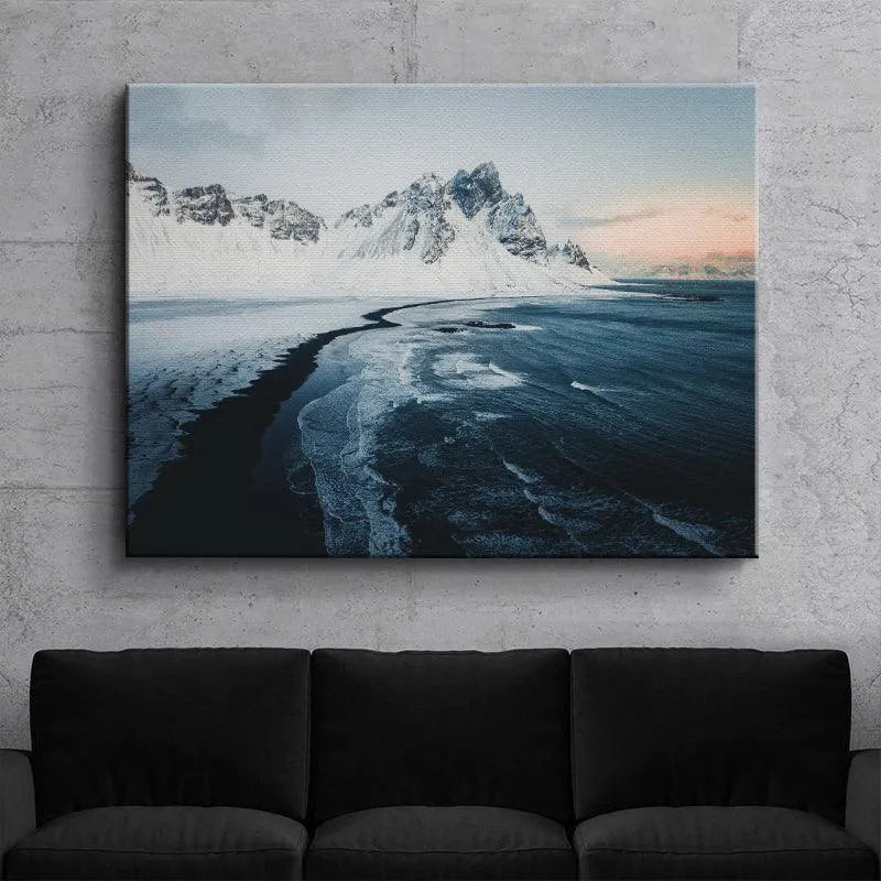 Aerial perspective highlighting the stark contrast between snow and ocean at Sunrise at stokksnes.