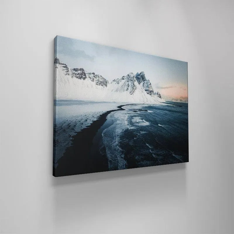 Long exposure representation of the crashing waves on the black sand during Sunrise at stokksnes.