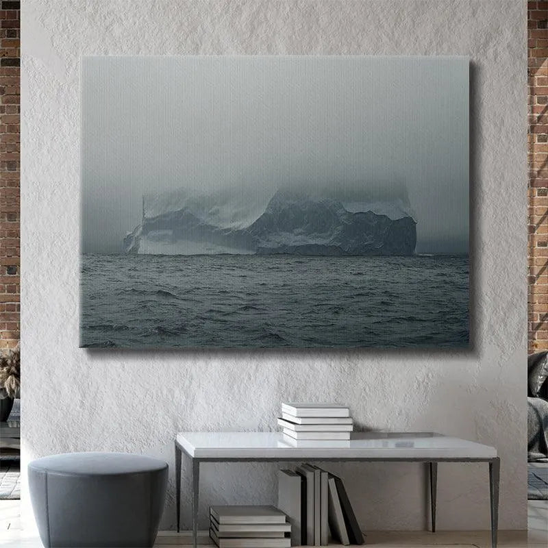 Atmospheric, moody photograph capturing the mist obscuring the peak of the immense floating mountain in The Arctic Walls Views.